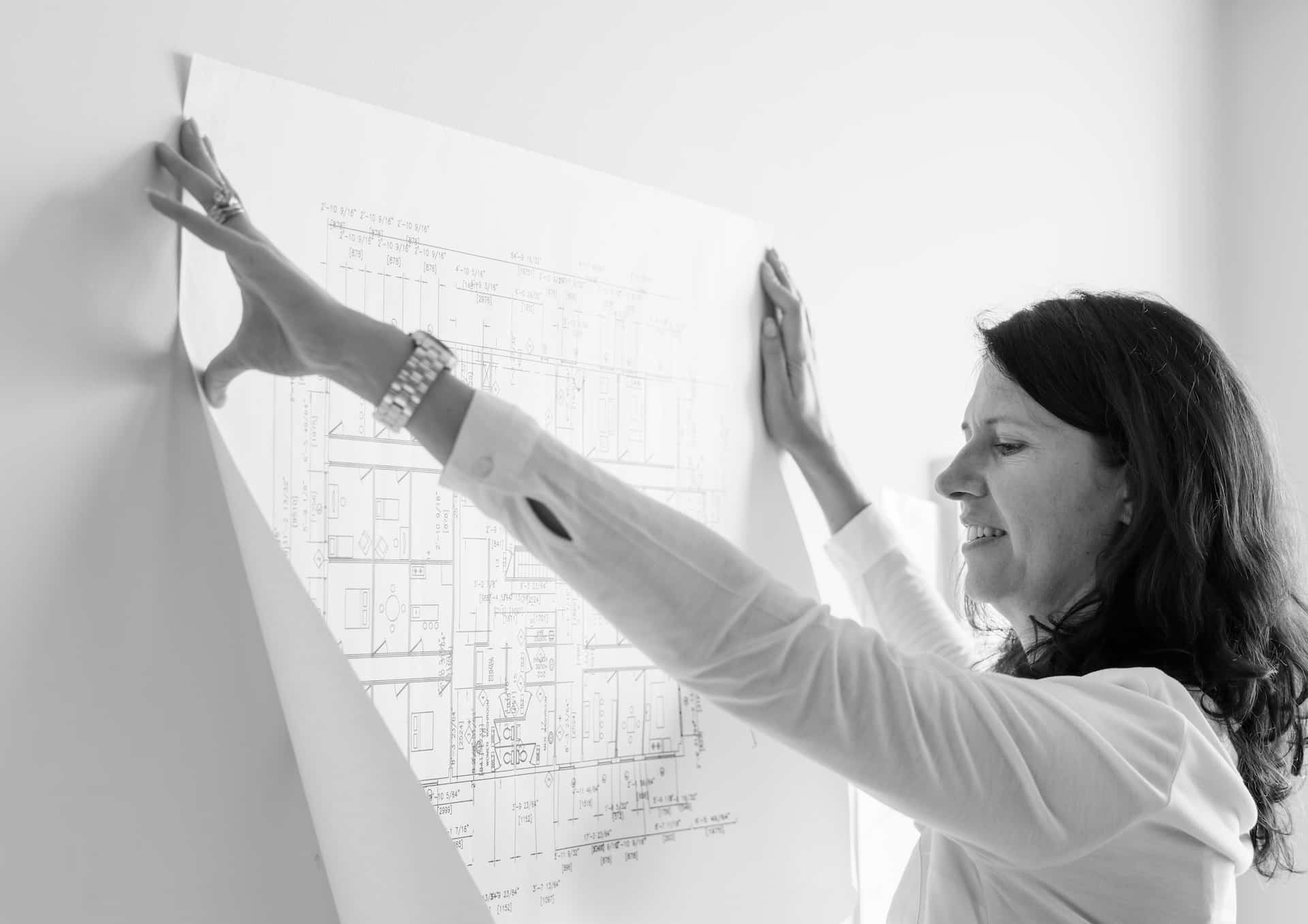 arquitecto-blanco-que-muestra-el-plan-de-construccion-en-la-pared-blanca (1)